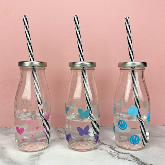 Dekorerade glasflaskor med hjärtan, fjärilar & emojis